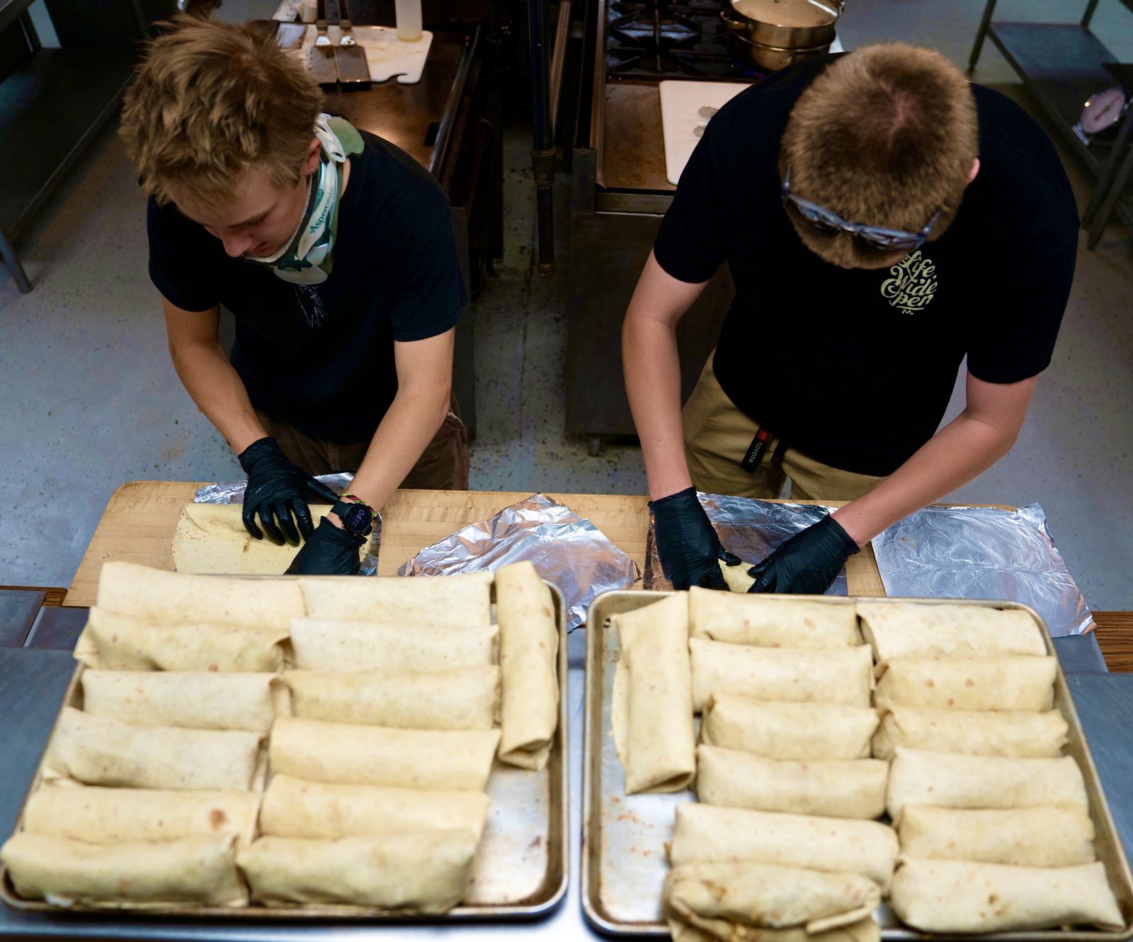 Team rolling and wrapping burritos