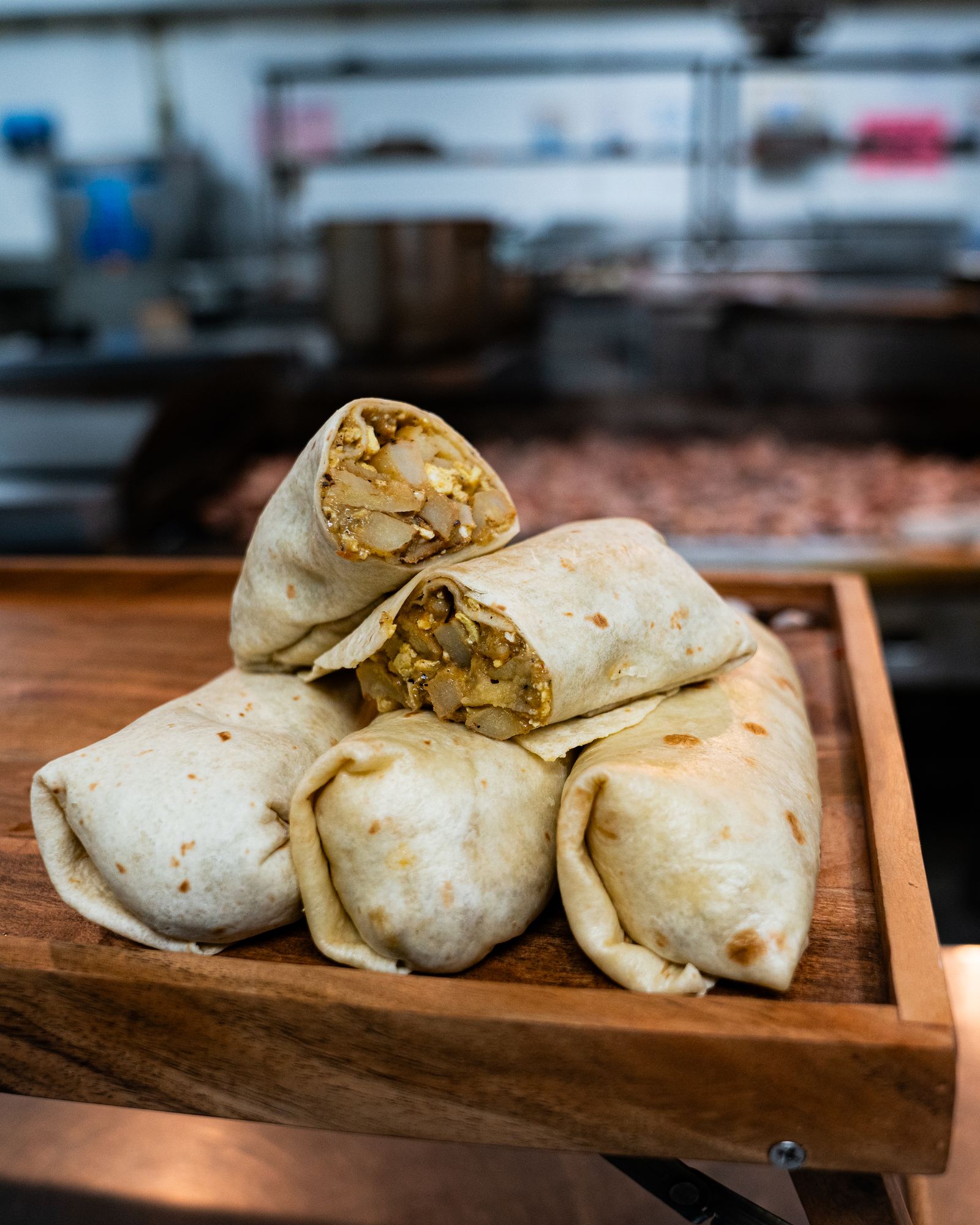 Rut'n'Buck breakfast burritos stacked on a cutting board