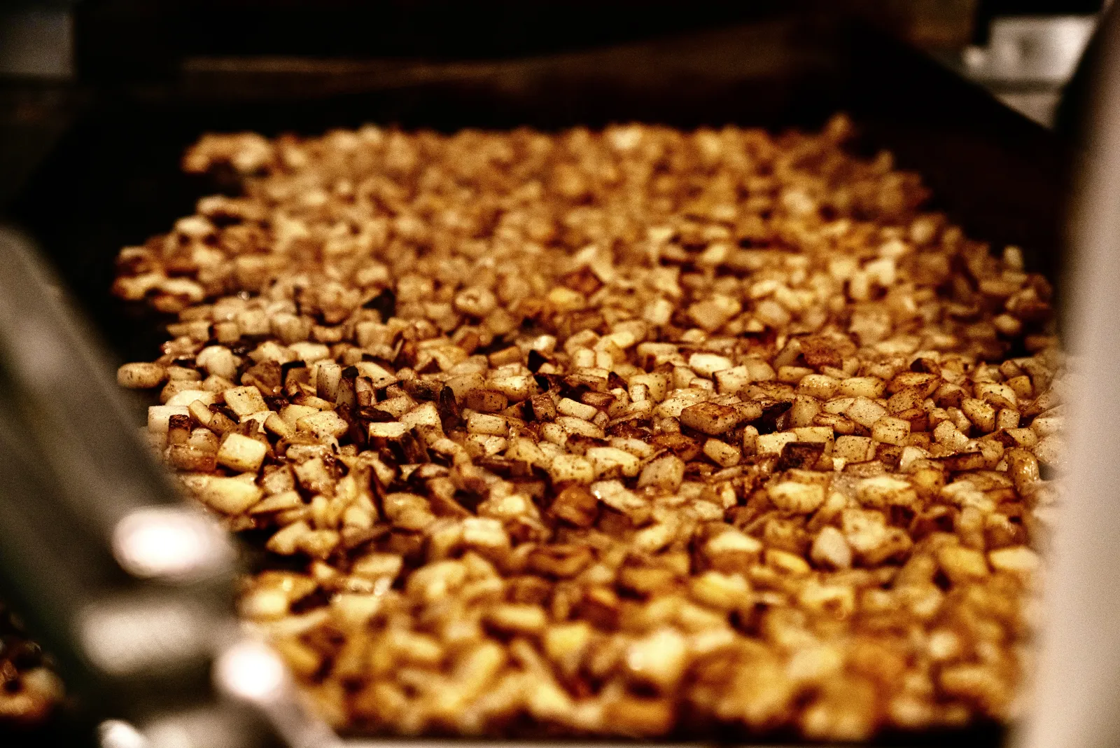 A big batch of diced potatoes seared on the flat-top griddle